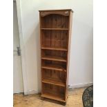 A modern pine open bookcase fitted five adjustable shelves on bun feet (179cm x 55cm x 29cm)