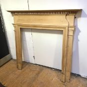 A Georgian inspired pine fire surround with dentil cornice and fluted pilasters (131cm x 144cm x