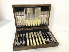 An oak cutlery canteen complete with a set of twelve knives and forks, marked R.Groves A1