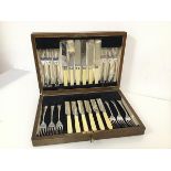 An oak cutlery canteen complete with a set of twelve knives and forks, marked R.Groves A1