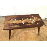 A modern South East Asian coffee table, with inlaid design depicting Figures Fishing, on tapering