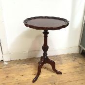 A reproduction mahogany Georgian style wine table with scalloped piecrust edge, on turned supports
