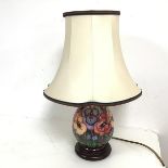 A ceramic table lamp of baluster form, in the style of Moorcroft (45cm to top of shade) (cracks to