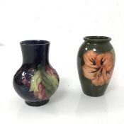 A 1930s/40s Moorcroft bud vase, with dark blue ground and grape and leaf decoration (10cm x 8cm) and