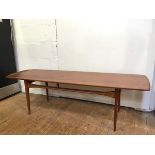 A mid century style teak coffee table, with raised edges to either end, on tapering supports with