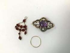 A garnet pendant (lacking one drop) (5cm) and an amethyst brooch and a yellow metal ring (0.98g) (