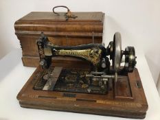 An early 20thc. Frister & Rossmann sewing machine, complete with travelling case, base bearing