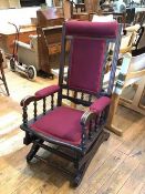 A 1930s/40s ebonised rocking chair with upholstered headrest, back and seat, rocking motion