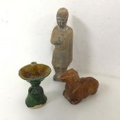 A clay figure of a Standing Man, possibly Chinese (19cm), a glazed figure of a recumbent sheep and a