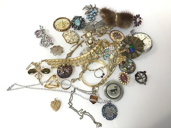 An assortment of costume jewellery including a silver thistle badge, paste and glass brooches, tie