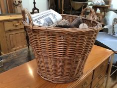 A wicker log basket with two handles and a quantity of logs (49cm x d.54cm)