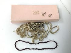 An assortment of imitation pearl necklaces and a pair of imitation pearl earrings and a garnet