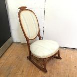 An early 20thc oak rocking chair with upholstered back and seat, on front turned supports and