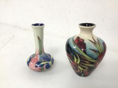 A Moorcroft bud vase of baluster form with an umbrella stamp to base (10cm) and another bud vase