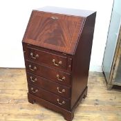 A neat reproduction mahogany bureau, the plain top above a fall front enclosing a fitted interior