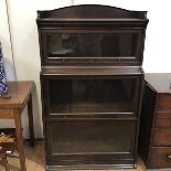 A 1920s oak Lebus bookcase, the top tier with dentil cornice and three quarter gallery above two