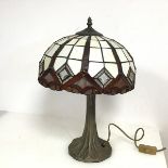 A Tiffany style lamp, the glass shade on a naturalistic metal base (46cm x 32cm)