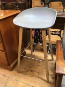 A bar stool with formed plastic seat on four splay supports united by metal box stretcher, marked