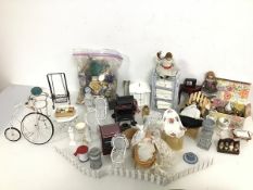 A collection of dolls' house furniture and homewares including garden chairs, barbeque, swing,