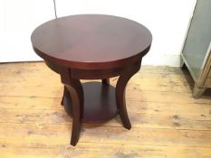 A mahogany circular two tier lamp table, the top with moulded edge raised on curved tapered splay
