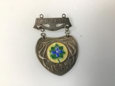 A silver and enamelled medal c.1938, inscribed Love Never Faileth and with the Norland Institute,