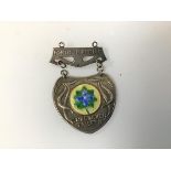 A silver and enamelled medal c.1938, inscribed Love Never Faileth and with the Norland Institute,