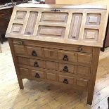 A modern oak bureau with panelled fall front, the interior with an arrangement of shelves above