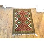 A kelim mat with allover diamond shaped medallions, with running dog border, sage green ground (82cm