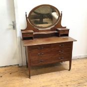 An Edwardian dressing table, the oval hinged mirror flanked by two drawers above an arrangement of