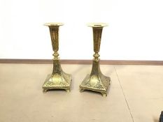 A pair of Persian style cast brass candlesticks, the tops of cylinder tapered form, raised on square
