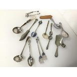 A silver pierced spoon (l.12cm) (17.98g) and an assortment of caddy spoons, cocktail forks, souvenir