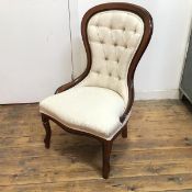 A reproduction walnut framed Victorian nursing chair with upholstered button back and seat, in