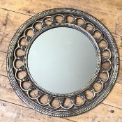 A modern circular composition wall mirror, the circular glass within a pierced edge with