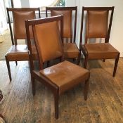 A set of four teak side chairs, each with a curved upholstered leather back and leather seat, on