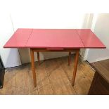 A 1960s extending kitchen table with coral coloured formica top on beech frame (extended: 77cm x