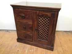 A modern padouk wood cabinet with three short drawers and single cabinet door with lattice front