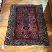 A Caucasian rug with central panel, with stylised flowers and running dog border within multiple