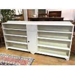 A large painted open bookcase with moulded ledgeback, with central fall front cabinet above a single