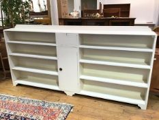 A large painted open bookcase with moulded ledgeback, with central fall front cabinet above a single