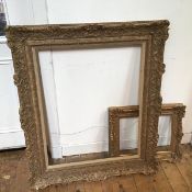 An elaborately moulded gilt picture frame (internal: 77cm x 62cm) and another smaller frame, with