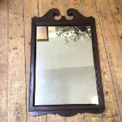 A wooden framed wall mirror, the rectangular plate in moulded frame with swan neck crest (75cm x