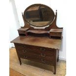 An Edwardian dressing table, the oval hinged mirror flanked by two jewellery drawers above an