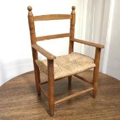 A mid 20thc beech Arts & Crafts style child's chair with seagrass woven seat on tapering turned