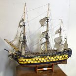 A wooden model of an early 19thc Warship, possibly HMS Victory, complete with stand (some losses) (