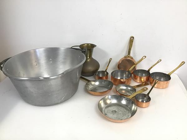 An assortment of small pans with copper bases and brass handles (largest: 3cm x 28.5cm x 14.5cm),