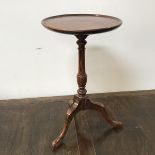 A reproduction Georgian style wine table with mahogany dished top on oak stem and tripod base (