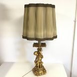 A modern gilt composition table lamp, with faux drip tray and seated putti on column base,