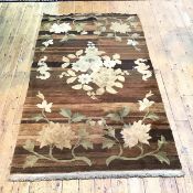 A 1920s Chinese washed wool rug with foliate design and bats on a brown tone field (213cm x 122cm)