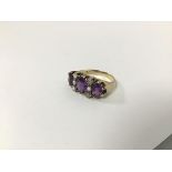 A 9ct gold ring set three amethysts with spacing rows of seed pearls (P) (6g)