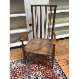 An Edwardian stained beech open arm child's chair with spar back above a rush seat, on turned